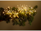 Warm white LED starburst lights on a green fir garland, creating a festive glow.