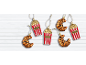 Popcorn and croissant Christmas ornaments on white wood.
