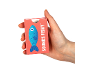 A red card game box with a fish illustration and the text Sounds Fishy, held in a hand.