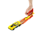 Yellow toy car on a launch platform, being pressed by a hand.