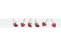 Red Christmas decorations shaped like stockings and bows on a white wooden background.