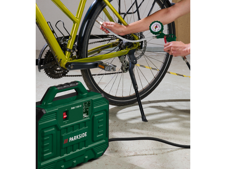 Green compressor inflating a bicycle tire.