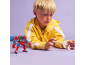 Boy playing with construction toys, including a red and blue robot and a white figure.