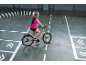 Woman in cycling gear on a bicycle, navigating a course with white lines and dominoes.