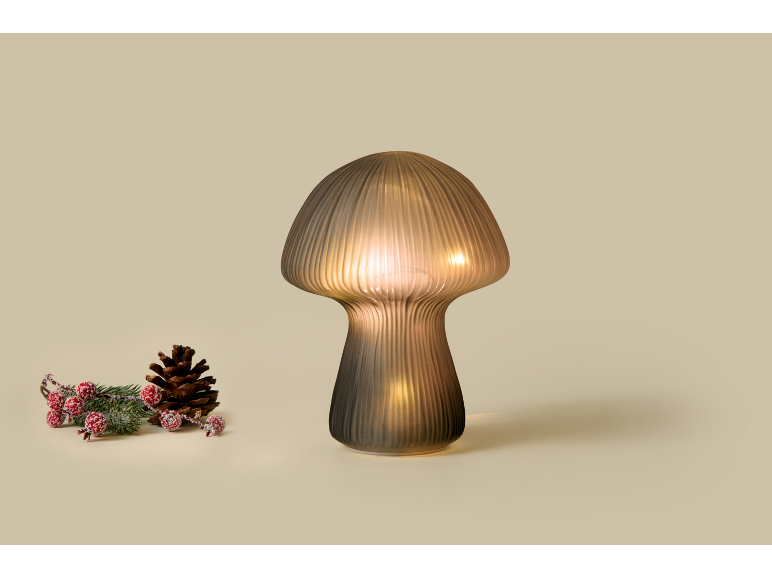 Mushroom-shaped table lamp with Christmas decorations on a beige background.