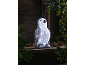 Light-up glitter penguin decoration, surrounded by foliage and pinecones.