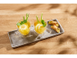 Two glasses of lemon and mint tea with lemongrass, served with pistachio cannoli on a tray.