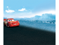Red racing car smiling in a desert landscape with blue sky.