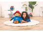 Girl lying on a fluffy rug with a large and small teddy bear in a child's room.