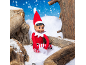 An elf sitting in the snow between wooden logs.