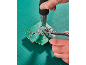 Hands using a heat gun and pliers to repair a green circuit board.