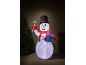 Inflatable snowman with a top hat, scarf, candy cane, and gift, next to a Christmas tree.