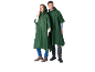 Two people in dark green rain ponchos, one woman and one man, standing.