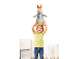 Smiling child holds a large plush rabbit above their head.