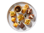 Plate of assorted sweets, including pistachio and honey baklava, chocolates, and coffee.