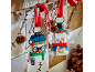Two festive snowman ornaments made of building blocks hanging from a branch with red ribbons