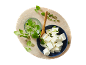 Feta cheese cubes with fresh oregano and chopped spring onions on a wooden board.