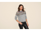 Woman in a grey patterned knit sweater and black faux leather trousers.