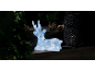 Christmas decoration with luminous deer, pine cones, and lantern in a dark setting.