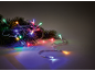 Fir branches with colorful Christmas lights on a dark background.