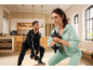 A man and a woman in sportswear doing squats with dumbbells at home.