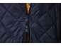 Blue quilted jacket with zipper over a yellow sweater.