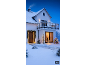 Outdoor Christmas lights and decorations on a snowy house.
