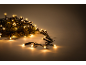 Warm Christmas lights on a pine branch, creating a festive ambiance.