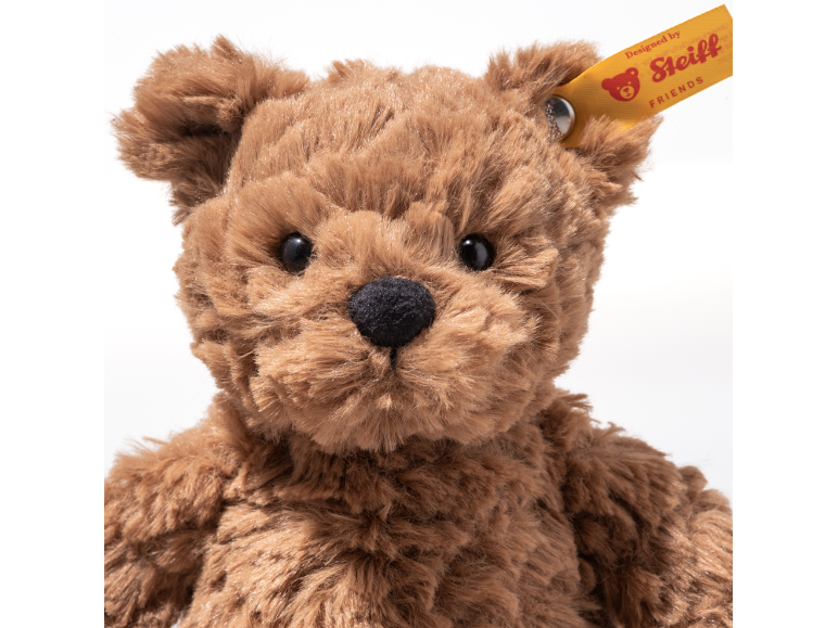 Fluffy brown teddy bear with a yellow tag in its ear.