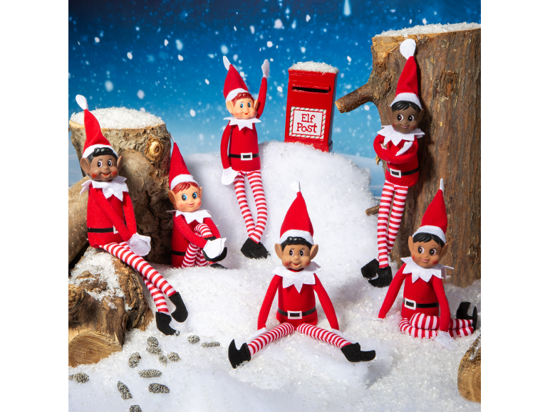 Six toy elves in a snowy landscape around a red postbox.
