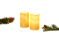Two LED candles with pine branch decorations and a red Christmas bauble.