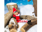 A Christmas elf sitting on wooden logs in the snow.