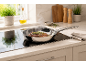 Frying pan with steak on an induction hob in the kitchen.