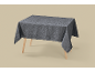 Grey damask pattern tablecloth on a wooden table
