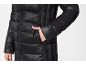 Black quilted jacket with a zipper and a hand in the pocket.