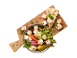 Greek salad with feta cheese, olives, vegetables, and pita bread on a wooden board.