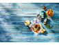 Grilled meatballs with salad, tzatziki, fries, and various spice shakers on a blue wooden table.