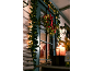 Lit Christmas wreath and garlands on the front door, with a candle on the table.