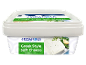 Greek style soft cheese with herbs and garlic in a white tub.