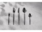 Black cutlery set with two forks, a knife, and two spoons on a light background.