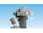 Grey and green toy tree with a falling orange and grey block, against a blue sky.