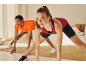 Woman and man in sportswear exercising at home.