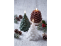 Three burning candles shaped like Christmas trees and a pinecone on a snowy background.