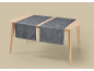 Two grey table runners with scroll pattern on a wooden table.