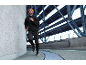 Man in black tracksuit and orange beanie with headlamp running in a tunnel.