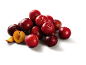 Pile of red plums, with one cut in half revealing the golden flesh.