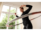 Woman in black tracksuit and leggings exercising with a hula hoop.