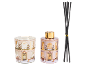 Candle and fragrance diffuser with Christmas house motifs and black sticks.