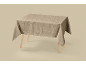 Beige tablecloth with a subtle filigree pattern on a wooden table.