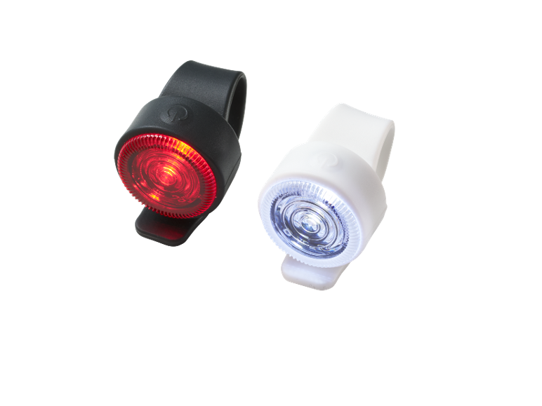 Red and white bicycle lights on a black background.